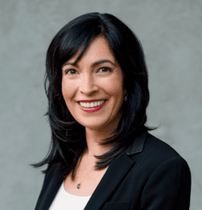 Joanna Lydgate, long dark hair, wearing black blazer with white undershirt